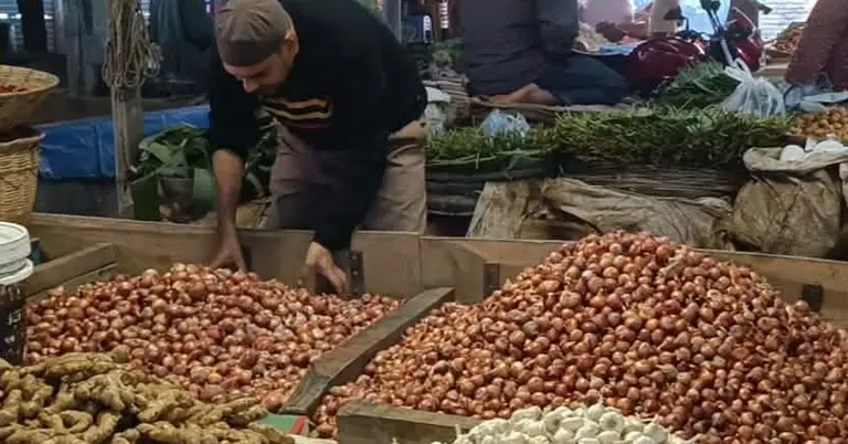 কাঁচাবাজার থেকে পেঁয়াজ কিনছেন এক ব্যক্তি